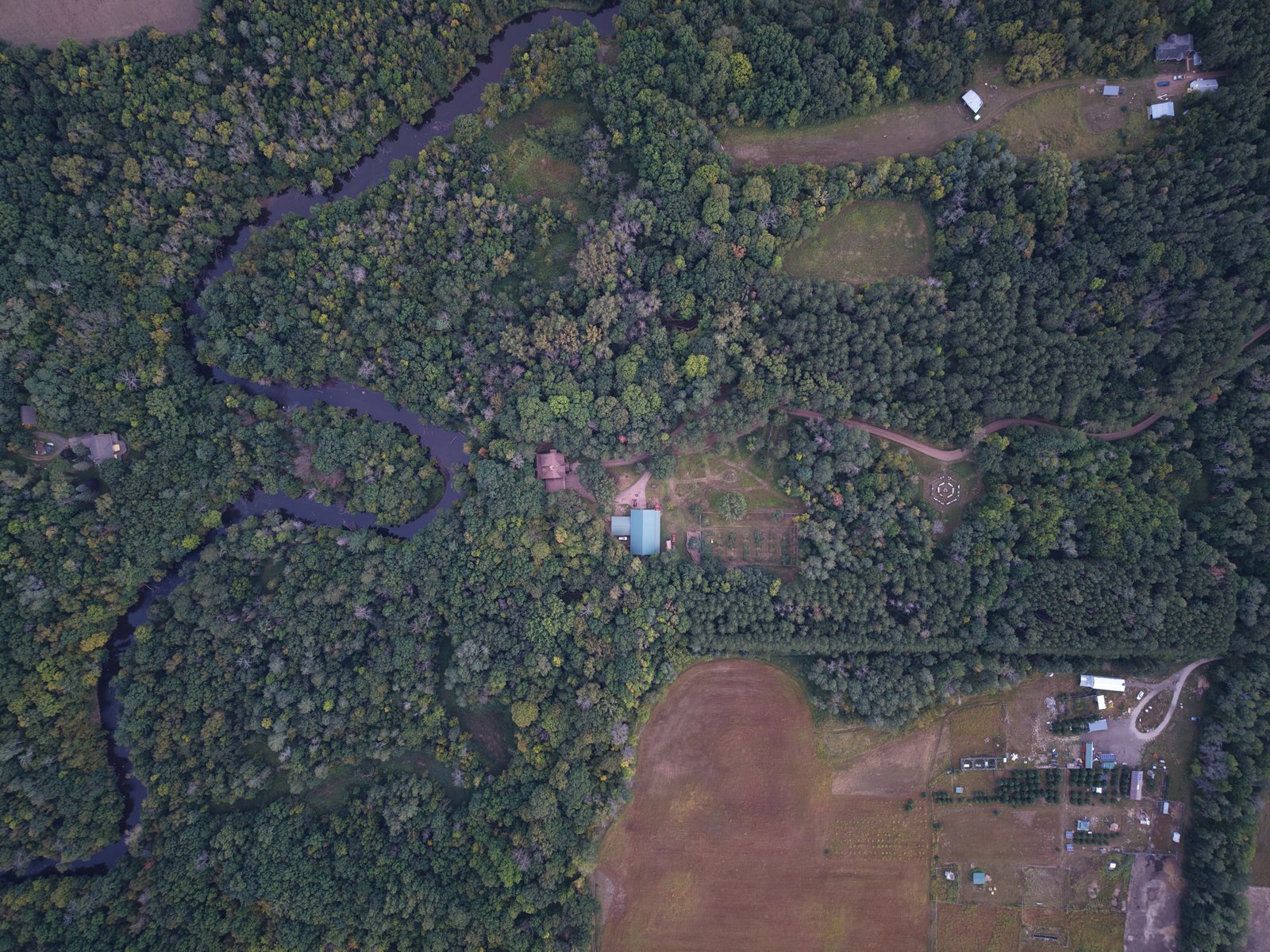 An aerial view across fields, forests, and a winding river
